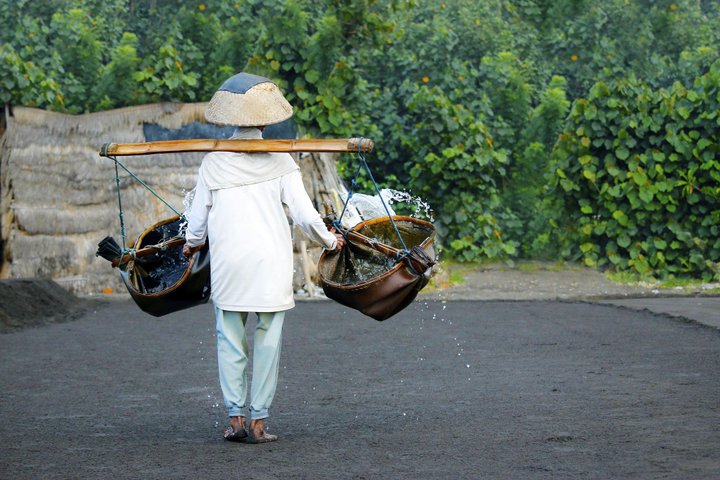 Balinese beim Wasserholen aus dem Meer für die traditionelle Salzgewinnung in Kusumba