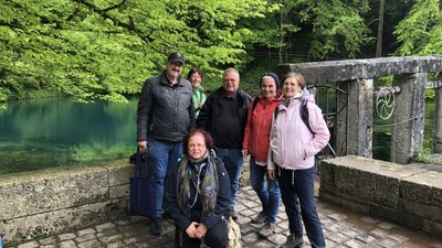 Klara Reischl von Zugvogeltouristik und Dr. Ingmar Braun mit einem Teil der Studienreisegruppe vor dem Blautopf