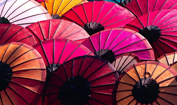 Die bunten Schirme am Markt sind typisch für Luang Prabang. Die Stadt ist UNESCO Welterbe und gehört zu Laos Reisen auf jeden Fall dazu.