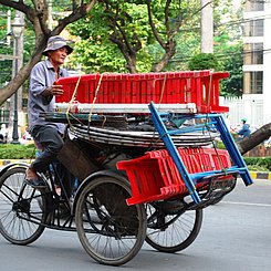 Fahrrad mit kleinen Plastikstühlen beladen