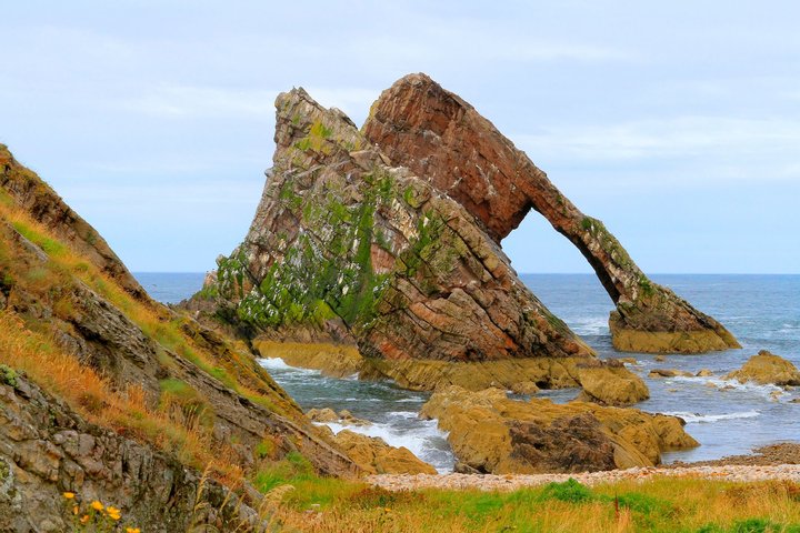 Portknockie hier steht die außergewöhnliche Felsformation Bow Fiddle Rock im Meer